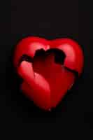 Бесплатное фото Плоское лежало разбитое красное сердце на темном фоне
