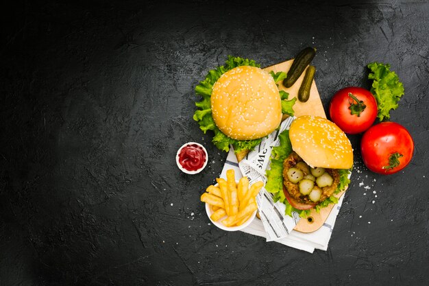 Flat-lay burger and fries on wooden board with copyspace