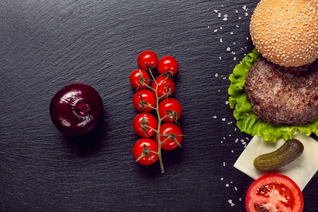 Foto gratuita ingredienti di hamburger piatto laici su sfondo di ardesia