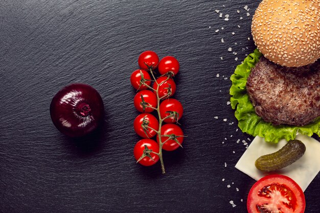 Flat lay burger ingredients on slate background