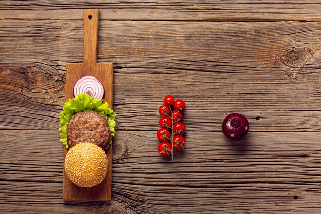 Flat lay burger ingredients on a wooden table