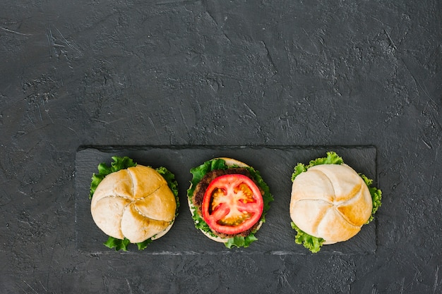 Hamburger piatto-lay su ardesia con copyspace