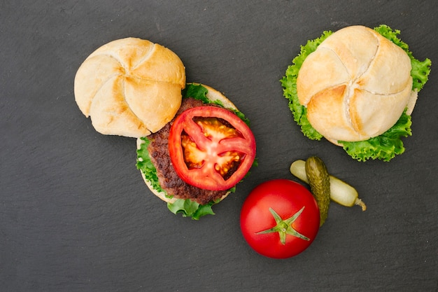 Foto gratuita hamburger piatto laici su ardesia