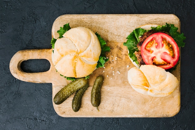 Free photo flat lay burger on wooden board