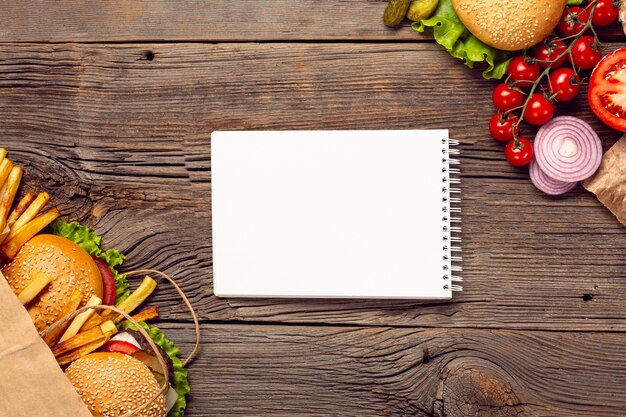 Flat lay burgers with mock-up notepad