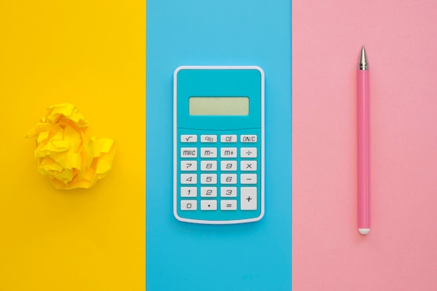 Flat lay of calculator with pen and crumpled paper