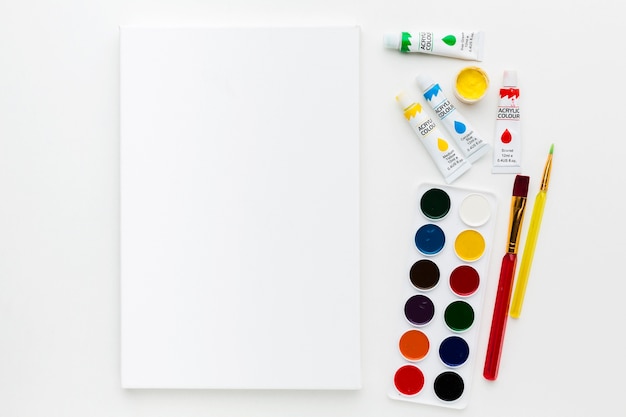 Free photo flat lay canvas and watercolor paint