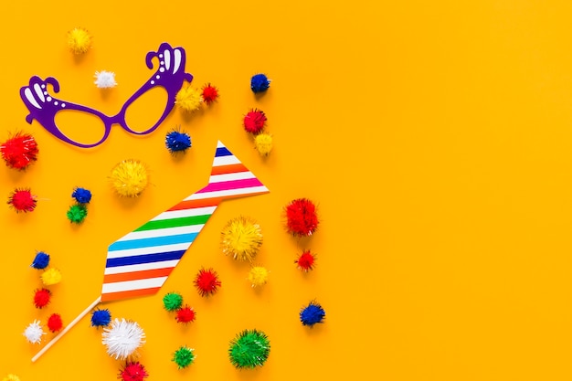 Free photo flat lay of carnival essentials with colorful pom-poms