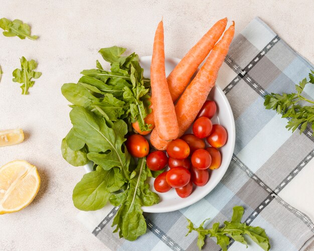 Free photo flat lay of carrots and tomatoes on plate