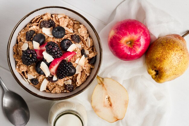 Flat lay cereal and forest fruits in bowl with milk