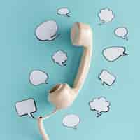 Free photo flat lay of chat bubbles with telephone receiver