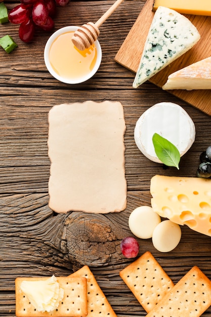 Flat lay cheese mix honey and grapes with blank cardboard