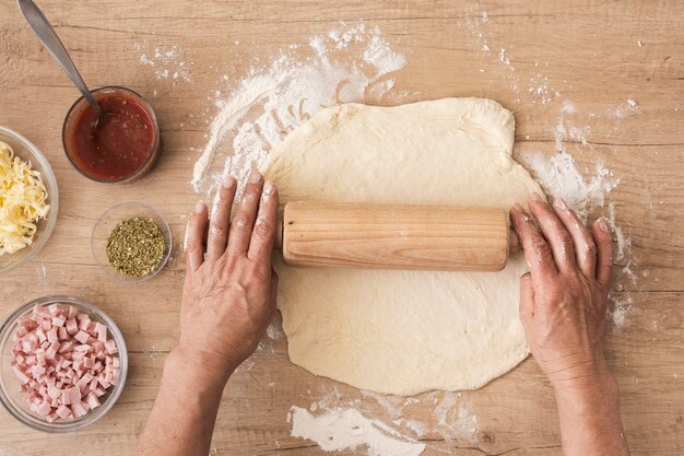 Flat lay chef rolling dough