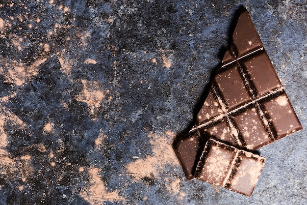 Flat lay chocolate covered in cocoa on grunge table