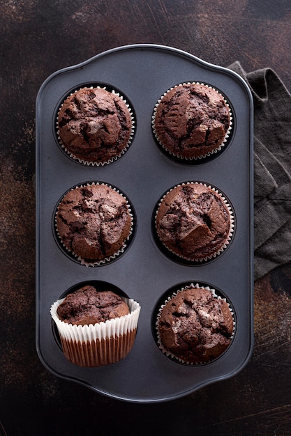 Free photo flat lay of chocolate muffins in tray with cloth