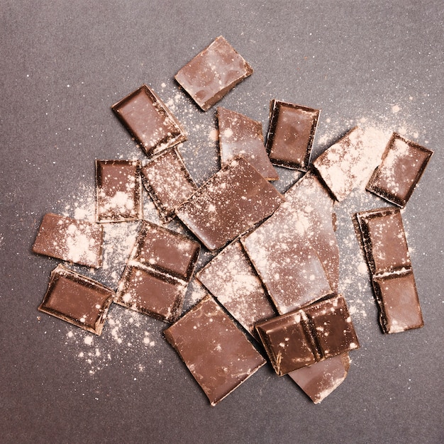 Flat lay chocolate tablets covered in cocoa powder