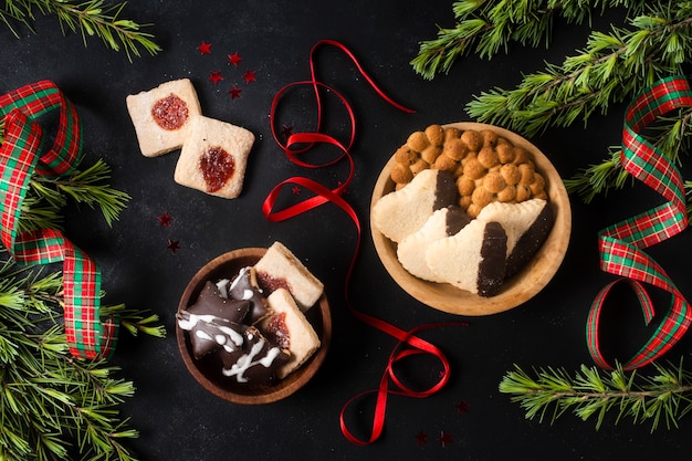 Free photo flat lay christmas goodies on black table