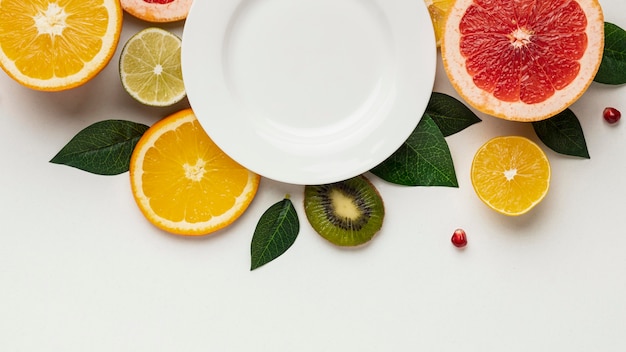 Flat lay of citrus with leaves and plate