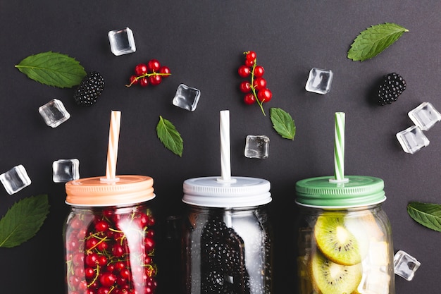 Free photo flat-lay close-up mason jars with berries and kiwi