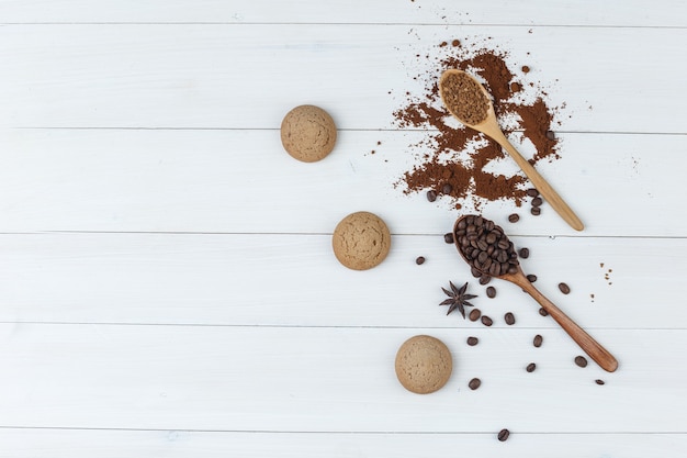 クッキーと木のスプーンで平らなコーヒー豆、木製の背景に挽いたコーヒー。水平