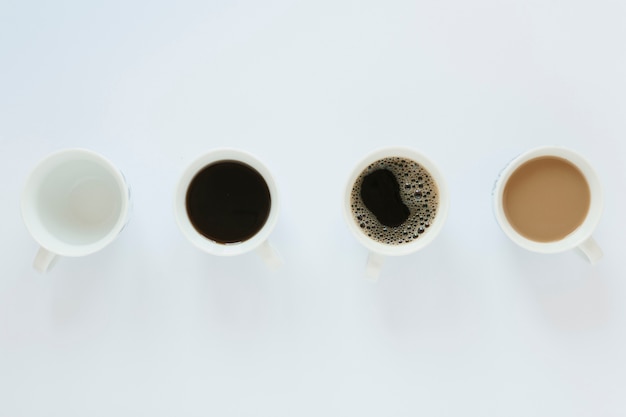Flat lay of coffee cups on white table