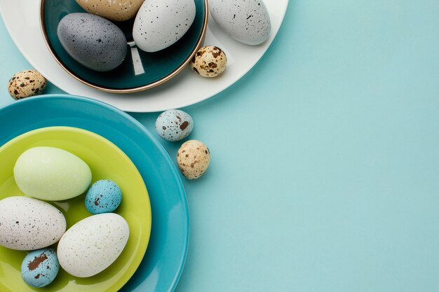 Flat lay of colored easter eggs on multiple plates