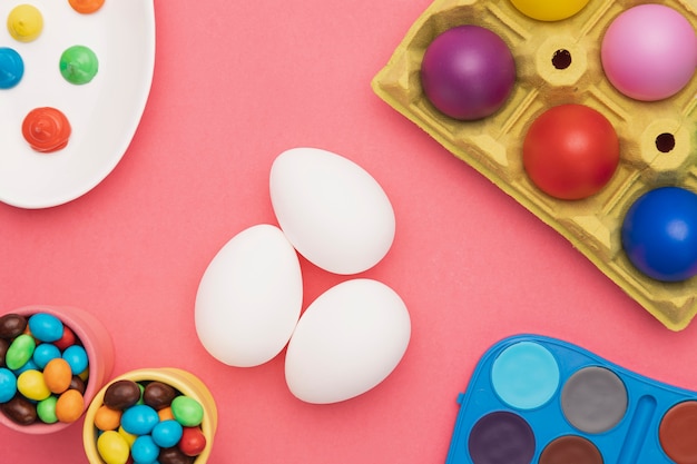 Flat lay colored eggs and coloring tools