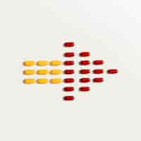 Free photo flat lay of colored pills forming an arrow