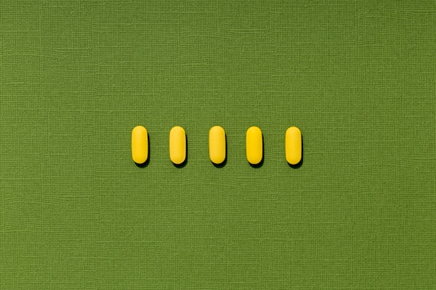 Free photo flat lay of colored pills in a row