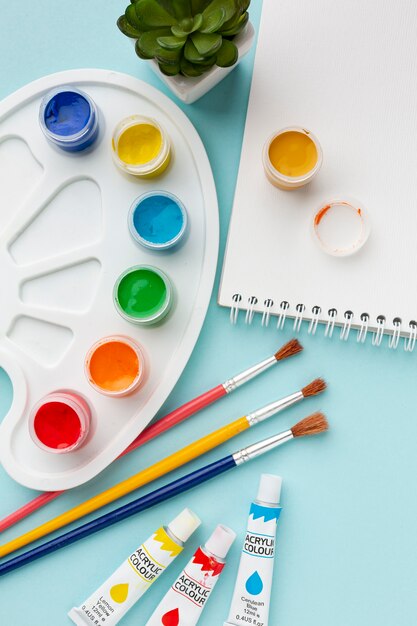 Flat lay of colorful aquarelle with notebook