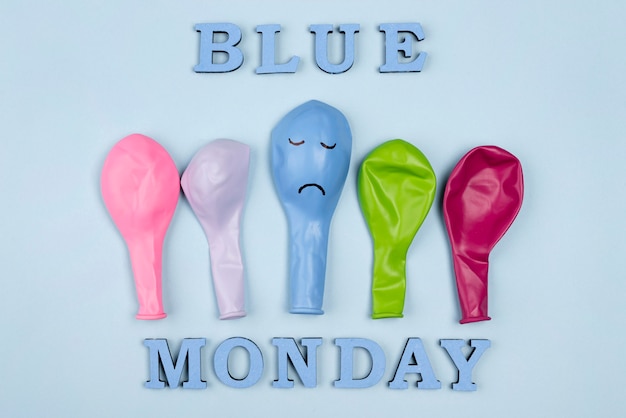 Плоская планировка разноцветных шаров с хмурым взглядом на синий понедельник