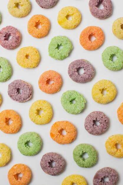 Flat lay colorful circular cereals on white background