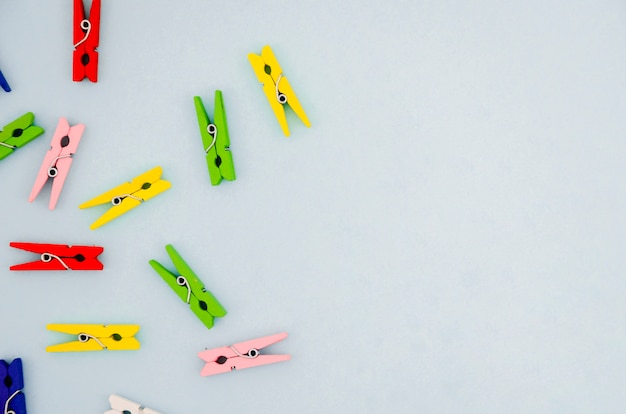 Flat-lay colorful clothes pins with copyspace
