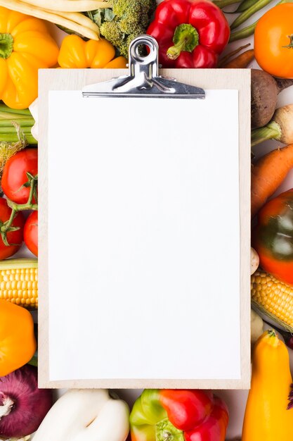 Flat lay colorful composition of vegetables with clipboard