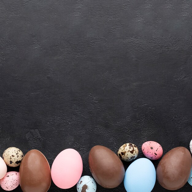 Flat lay of colorful easter eggs and chocolate ones