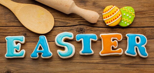 Flat lay of colorful easter eggs with rolling pin and wooden spoon