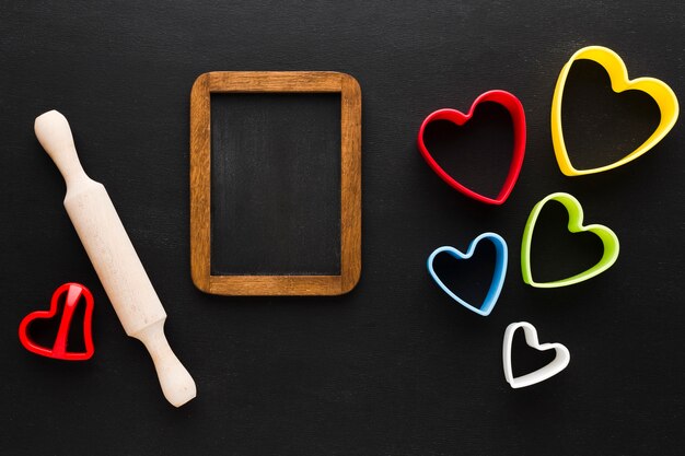 Flat lay of colorful heart shapes with rolling pin