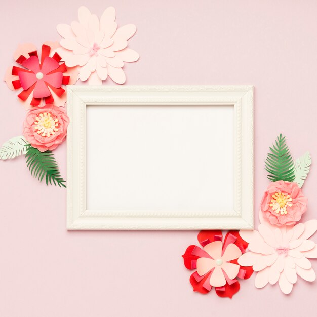 Flat lay of colorful paper flowers and frame
