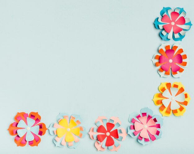 Flat lay of colorful paper flowers for spring with copy space