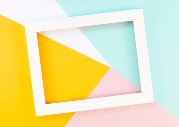 Flat lay of colorful paper shapes with frame on top