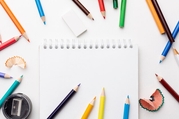 Flat lay of colorful pencils and notebook