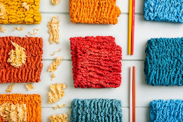 Flat lay colorful ramen noodles and colorful chopsticks