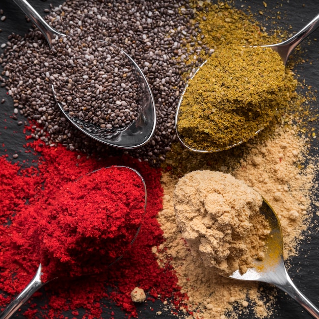 Free photo flat lay colorful spices on black background