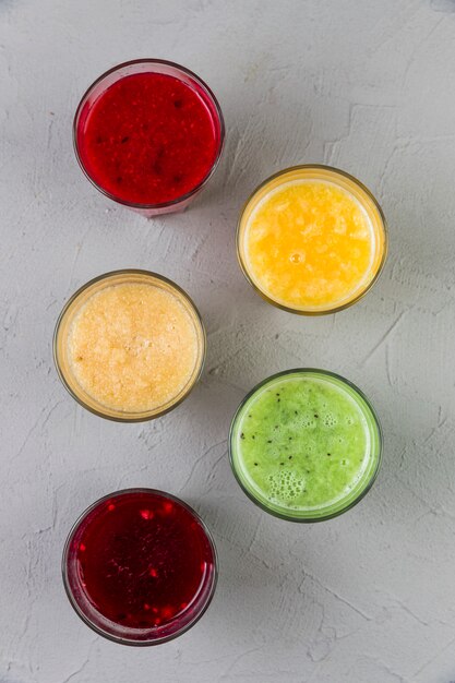 Flat lay colourful smoothie glasses