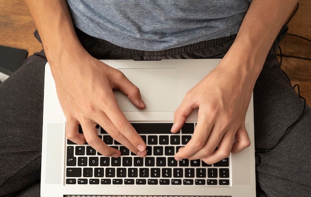 Flat lay of comfortable man in quarantine at home using laptop for work