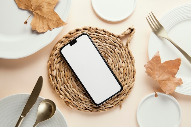 Flat lay composition of beautiful tableware with empty smartphone