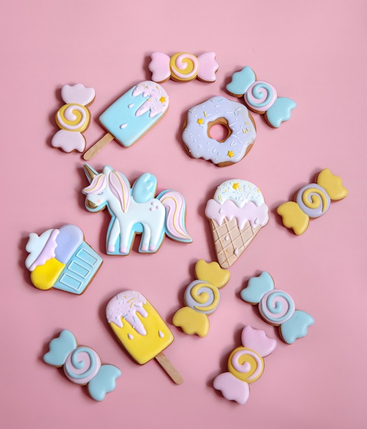 Flat lay composition with bright glazed gingerbread cookies on pink background.