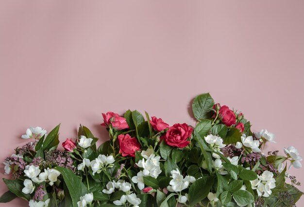 Flat lay composition with fresh flowers on pink surface