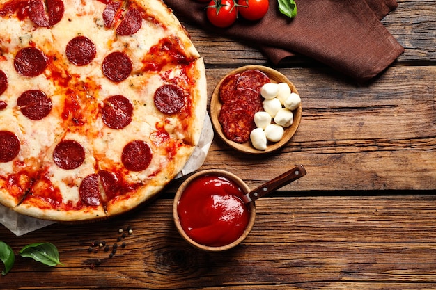 Flat lay composition with hot pepperoni pizza on wooden table