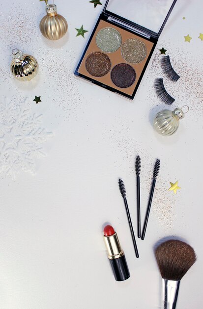 Flat lay composition with makeup products and christmas decor on white background. template for design, top view flat lay copy space.
